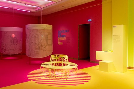 Foto der Bank "Nur für Rentner" am Übergang vom Gelben zum Pinken Raum in der Ausstellung Dialog mit der Zeit.