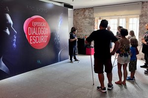 A group of people looks at the dialogue in the dark display stands