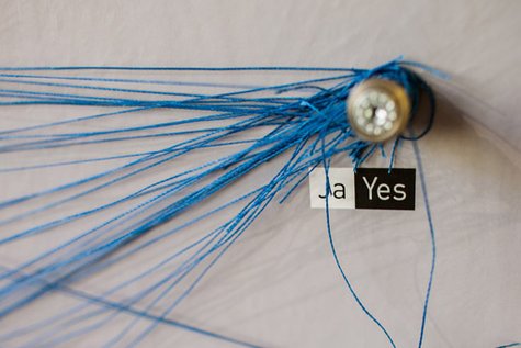 Detailfoto von vielen blauen Fäden, die an einem Punkt zusammenlaufen, der mit "Ja" beschriftet ist.