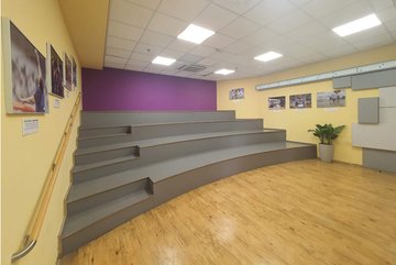 Photo of the new lobby in Holon with stepped benches for the visitors and pictures of the Paralympics in Tokyo on the walls.